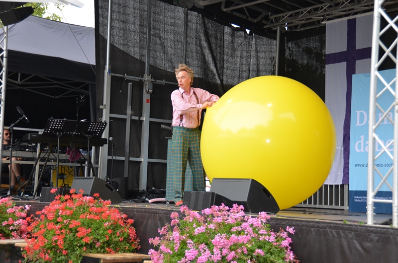 Clown Tilo Schoppe mit einem großen gelben Ball auf der Bühne.