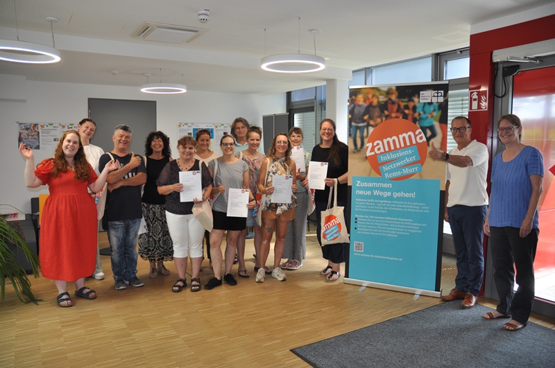 Gruppenfoto der Inklusionsbegleiter*innen zusammen mit Kursleiterin Lisa Batur und Dietmar Prexl, dem Vorstandsvorsitzenden der Diakonie Stetten. 