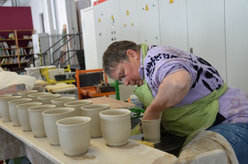 Eine Person arbeitet an einer Drehscheibe in der Töpferei im Kreativen Bereich der Remstal Werkstätten in Schorndorf. Eine Person arbeitet an einer Drehscheibe in der Töpferei im Kreativen Bereich der Remstal Werkstätten in Schorndorf.