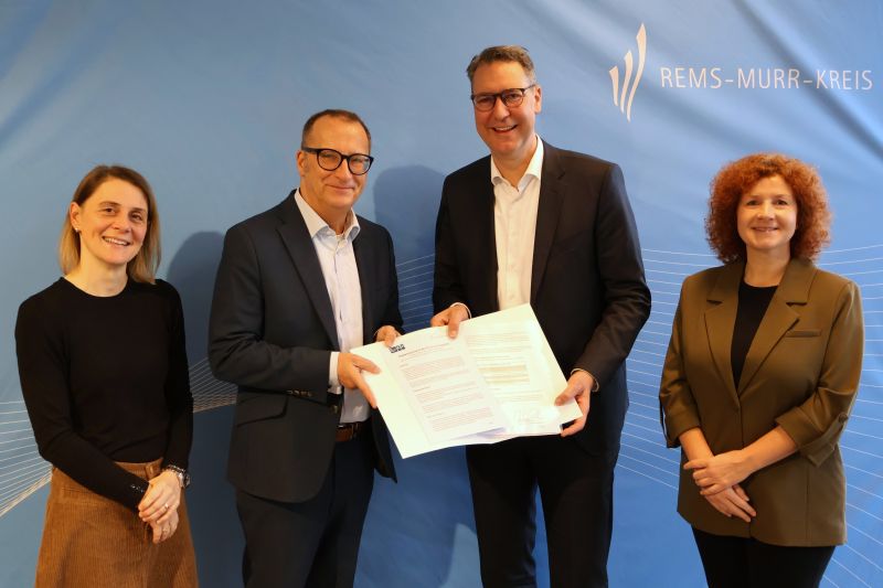 Vier Personen stehen nebeneinander. Die unterzeichnete Absichtserklärung wird Richtung Kamera gehalten. Vier Personen stehen nebeneinander. Die unterzeichnete Absichtserklärung wird Richtung Kamera gehalten. Zu sehen sind von links nach rechts von der Diakonie Stetten die Geschäftsbereichsleiterin Verwaltung und Dienstleistung sowie der Vorstandsvorsitzende, für den Rems-Murr-Kreis der Landrat und die Leiterin des Dezernats für Soziales, Jugend und Bildung.
