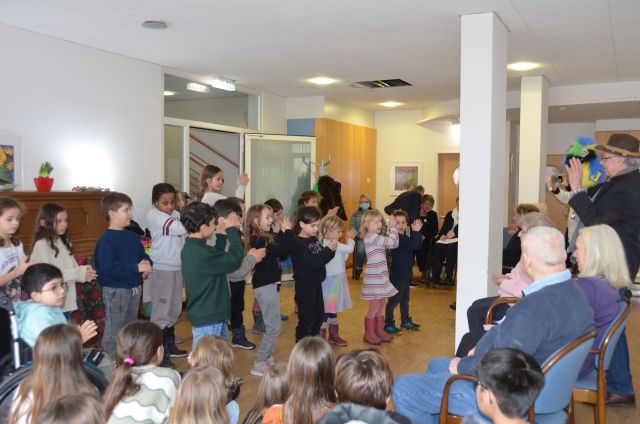 Schülerinnen und Schüler der Katharinenschule singen und klatschen stehend inmitten von Seniorinnen und Senioren der Ganztagesbetreuung des Alexander-Stifts der Diakonie Stetten in der Richard-Hirschmann-Straße in Esslingen. Schülerinnen und Schüler der Katharinenschule singen und klatschen stehend inmitten von Seniorinnen und Senioren der Ganztagesbetreuung des Alexander-Stifts der Diakonie Stetten in der Richard-Hirschmann-Straße in Esslingen.