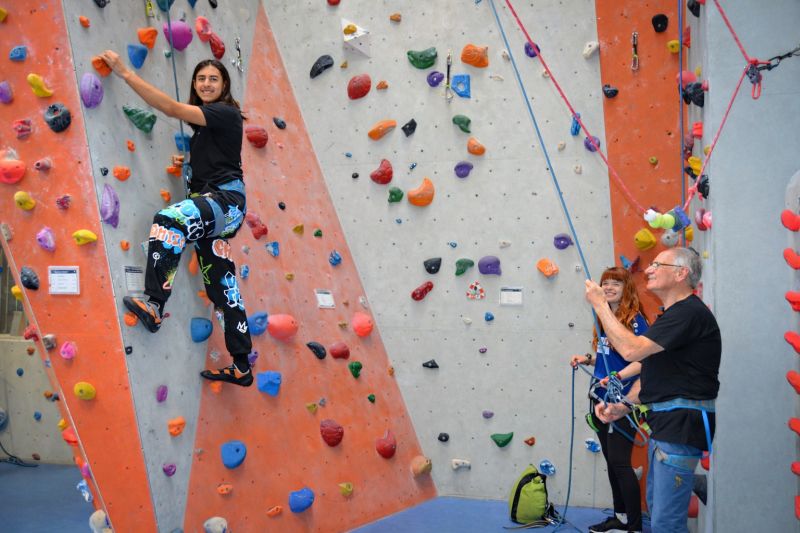 Eine Person klettert von zwei weiteren Personen gesichert in der Kletterhalle cityrock in Stuttgart Mitte.
