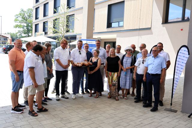 Zahlreiche Personen stehen am Tag der Einweihung bei der symbolischen Schlüsselübergabe am neuen Pflegezentrum.