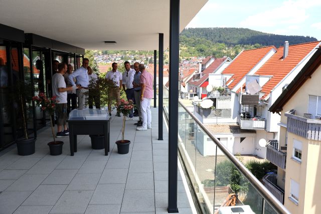 Mehrere Personen stehen auf einem Balkon des neuen Pflegezentrums mit Aussicht auf Rudersberg.