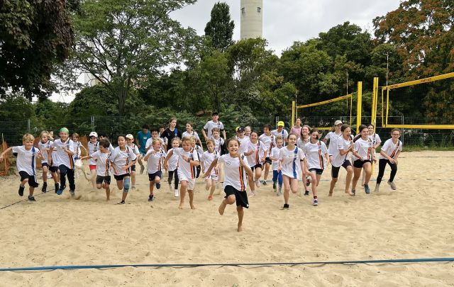 Mehrere Kinder rennen über einen Sandplatz Richtung Kamera. Mehrere Kinder rennen über einen Sandplatz Richtung Kamera.