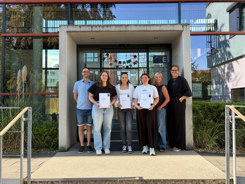 Sechs Personen stehen vor dem Eingang der Ludwig Schlaich Akademie